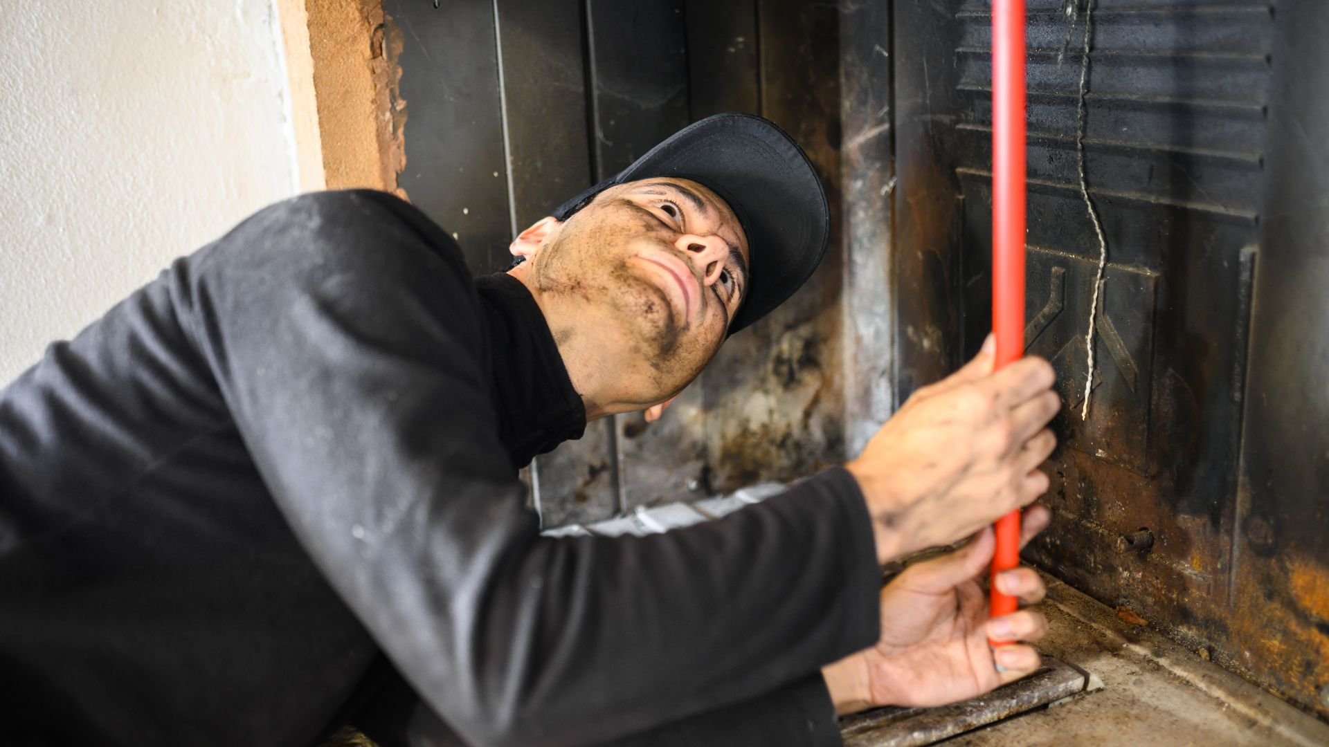 Worker in black cap checks industrial machinery or equipment