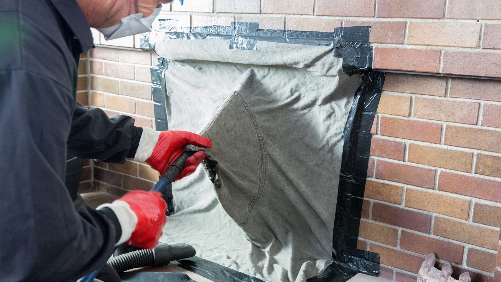 Worker in red gloves sealing insulation material on brick wall