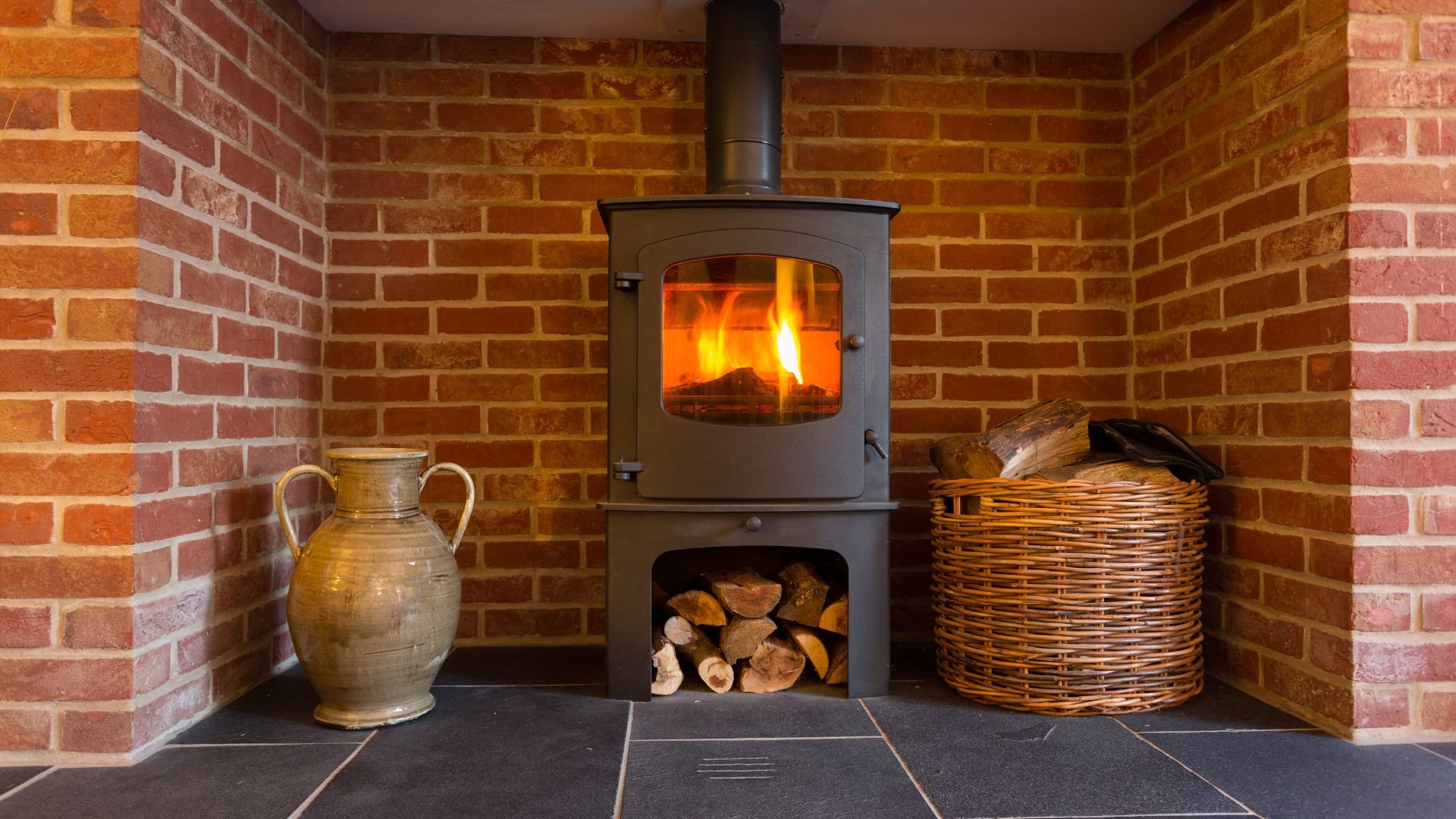 Cozy wood-burning stove with fire burning, brick walls, and woven baskets